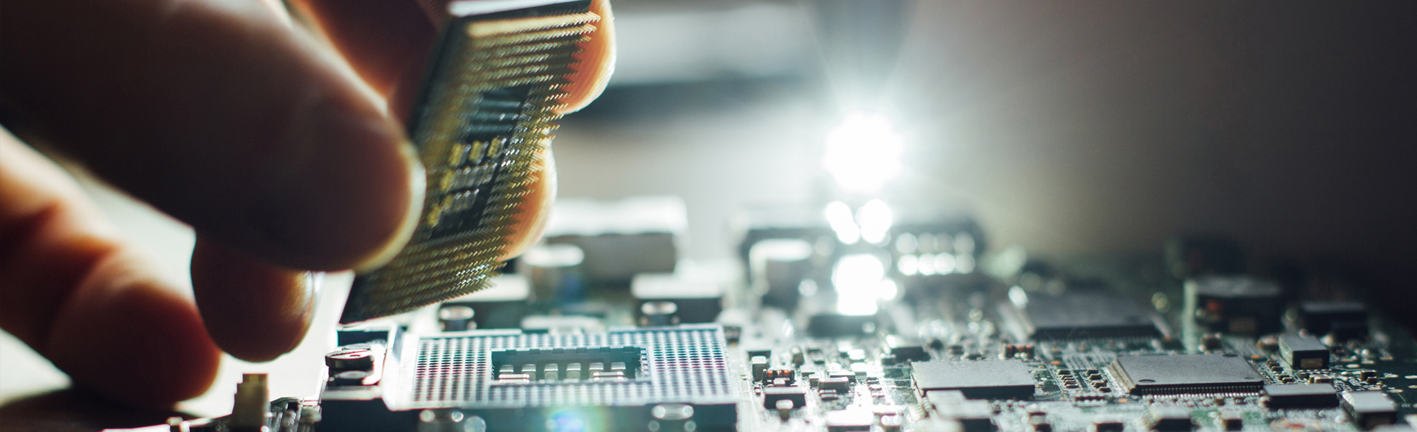 Técnico segurando um processador sobre uma placa de circuitos